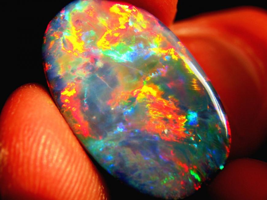 A smooth round stone that appears to glow with multi-colored bursts of light inside