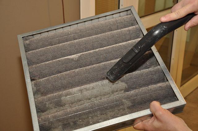 A common air filter, being cleaned with a vacuum cleaner.