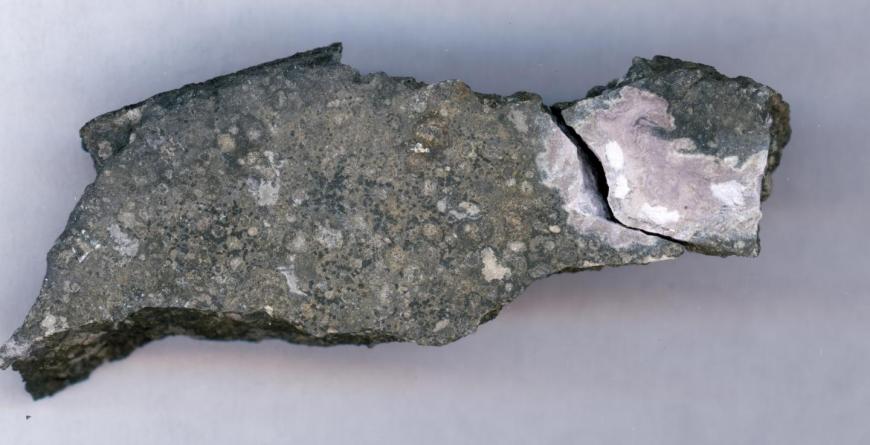 ceramic-like refractory inclusion (pink inclusion) still embedded into the meteorite in which it was found