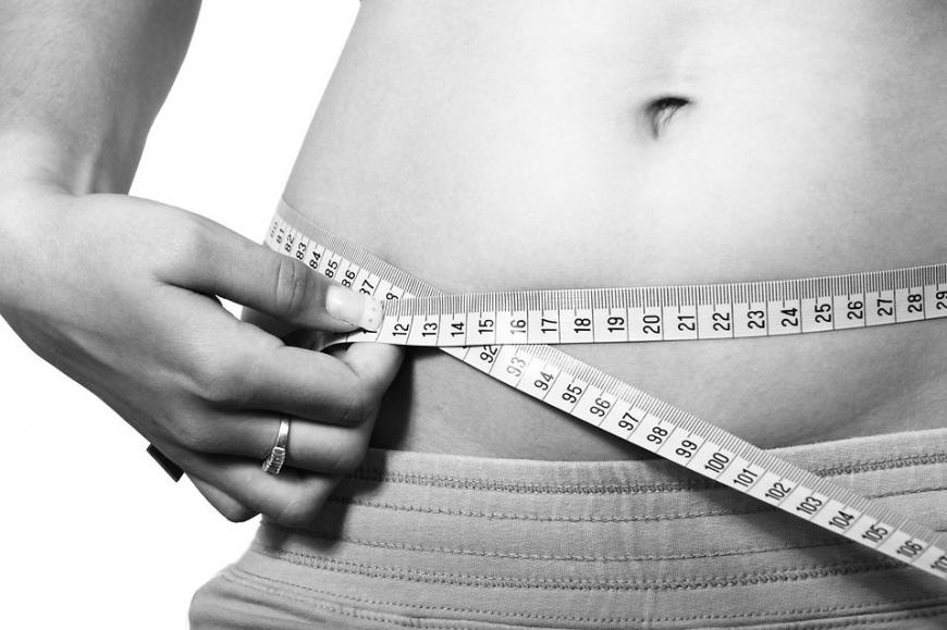 Woman measuring waist. Black and white photo.