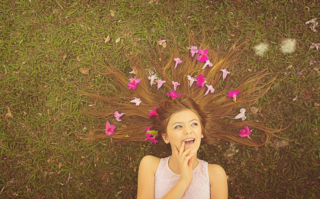 Daydreaming girl lying down with flowers in her hair.