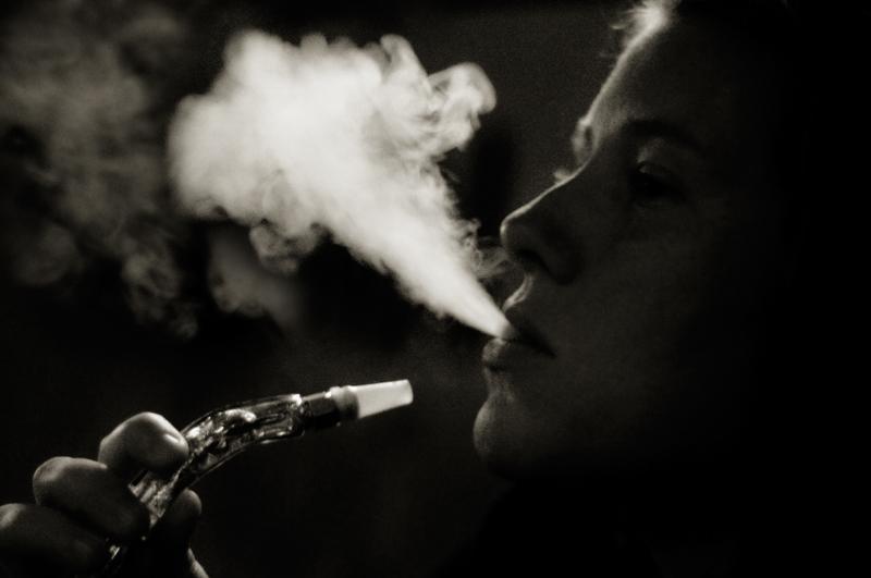 Black and white photo of a person smoking a hookah
