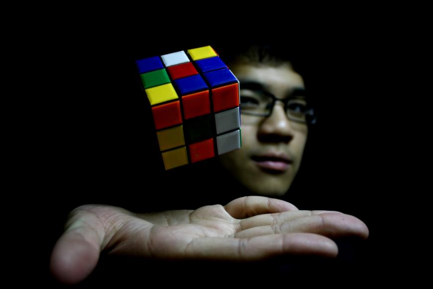 Telekinesis. Rubik&#039;s cube levitating above man&#039;s hand
