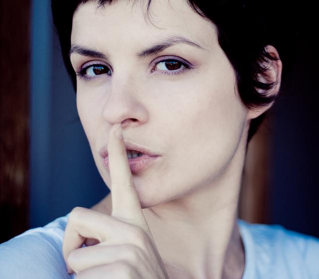 Woman with her finger in front of her lips. Shhhhh
