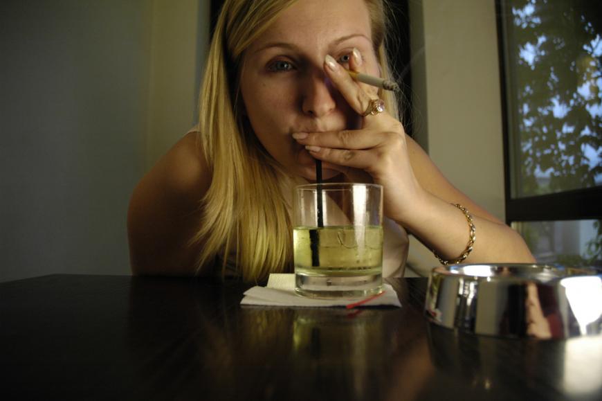 Woman smoking and drinking an alcoholic beverage