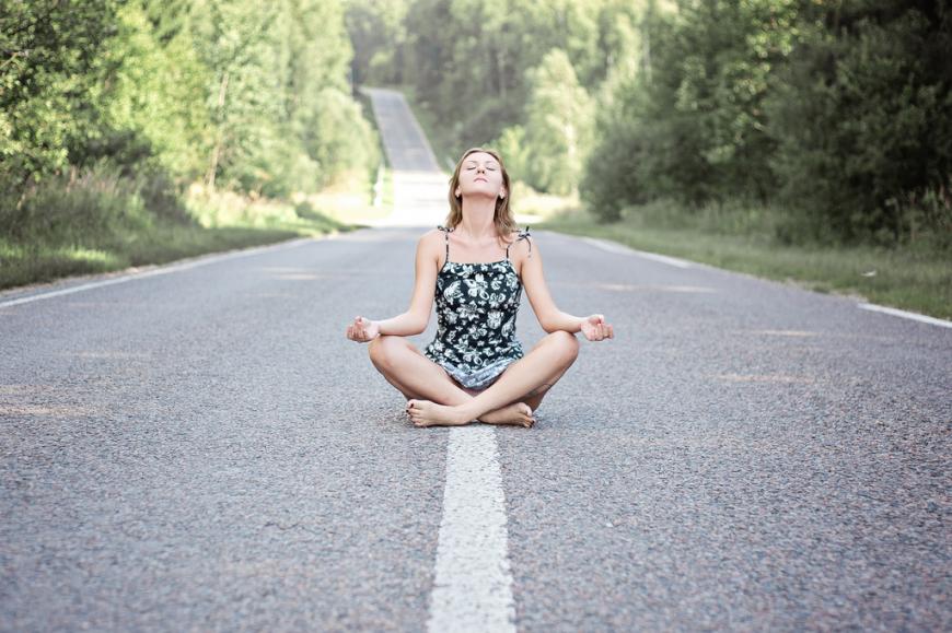 Woman meditating on a road