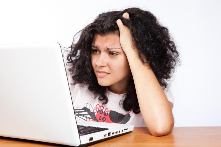 Woman staring in anguish at her laptop