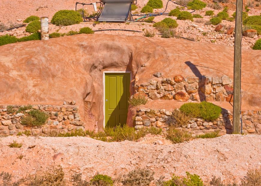 A green door built into a sandstone cliff
