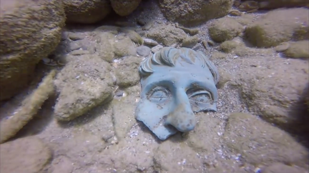 Fragment of a bronze mask on the seafloor
