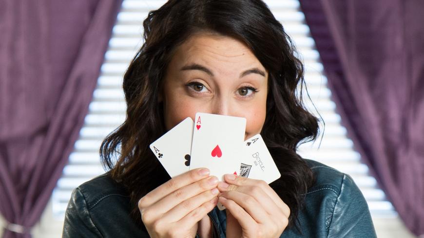 Woman fans playing cards in front of her face