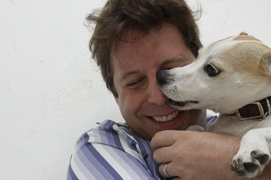a jack russell terrier licking the nose of its owner