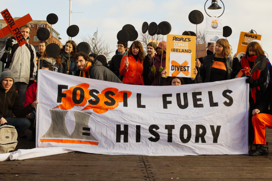 Protesters with banner reading &quot;Fossil Fuels = History&quot;