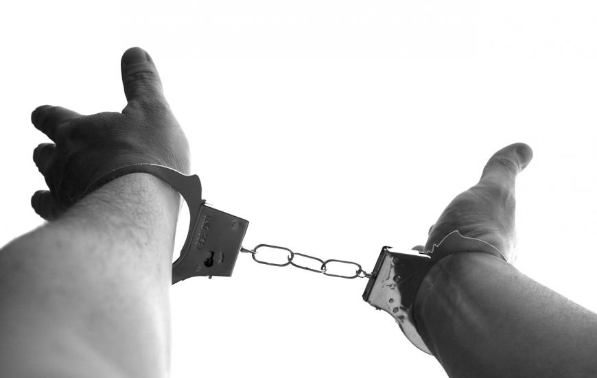 Hands in handcuffs, black and white photo