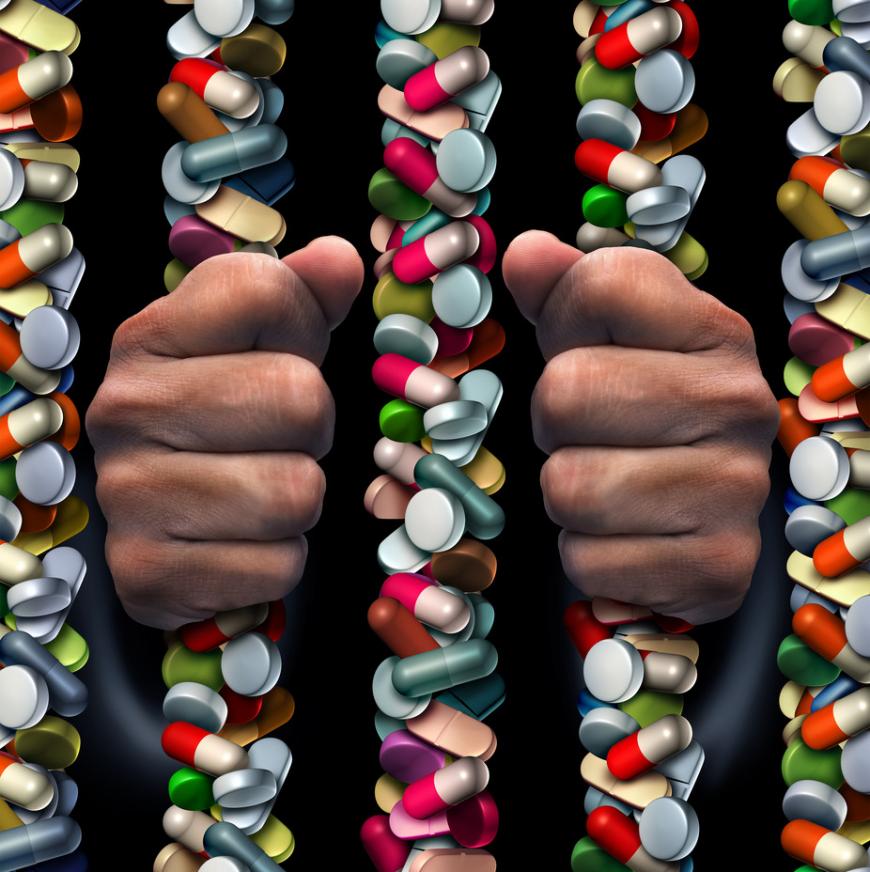 Addiction. Hands grasp prison bars made of pills