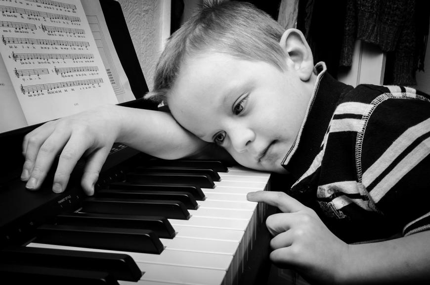Young boy at the piano keyboard.