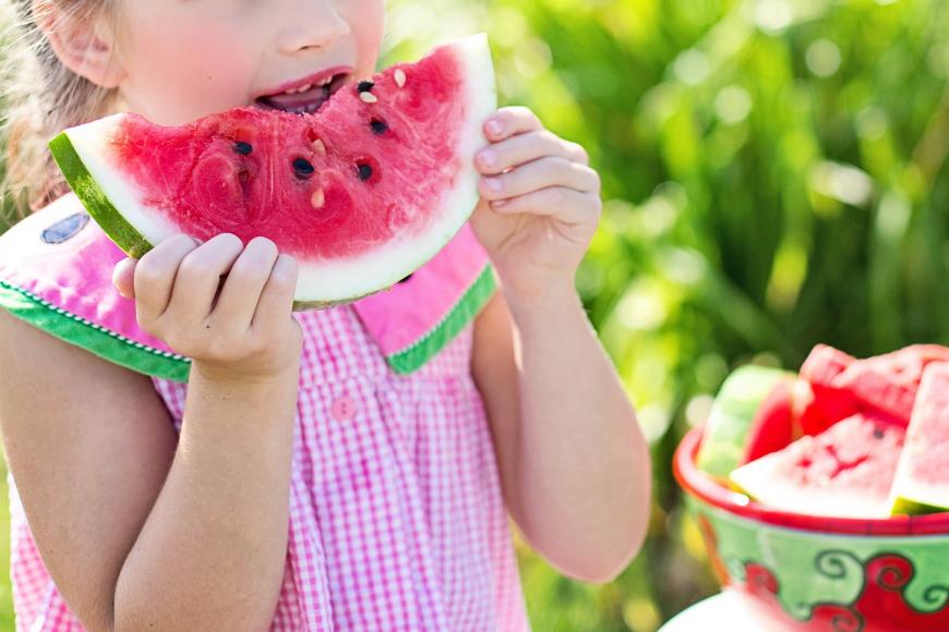 Young girl eating watermelon on a summer day