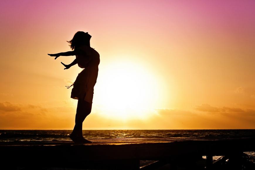 woman posing in front of a sunrise
