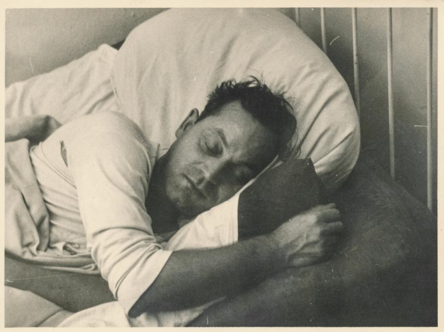Old black and white photo of a man sleeping in bed