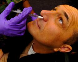 Man receives his annual Influenza vaccine in the form of a nasal mist