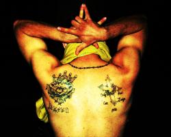 Latin King gang member showing his gang tattoos, and hand sign.