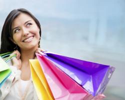 Woman smiling and carrying colorful shopping bags