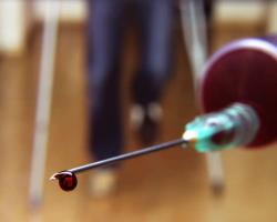 Blood dripping from the needle of a syringe