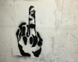 Graffiti in black of a middle finger