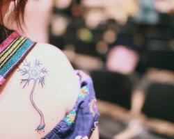 Tattoo of a neuron on a woman&#039;s shoulder