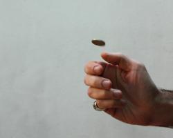 A hand flipping a coin into the air