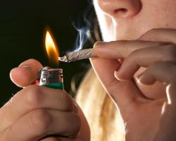 young woman smoking pot or marijuana. Lighter