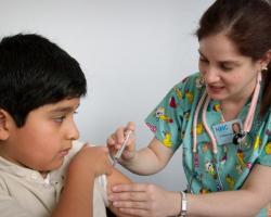 Nurse delivers an intramuscular vaccination to a young child