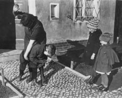 black and white photo of a father spanking his children