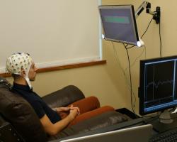 Study participant wears an electroncephalography (EEG) cap that records brain activity