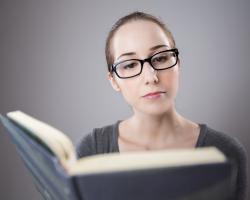 woman in glasses reading a book