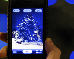 An iPhone taking a photo of a Christmas tree