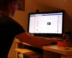 Man using Facebook on his desktop computer