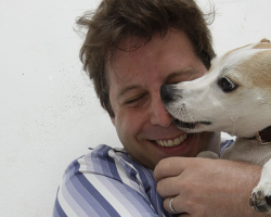 a jack russell terrier licking the nose of its owner
