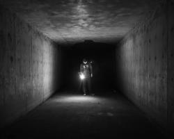 Darkness, a dark tunnel illuminated by a flashlight