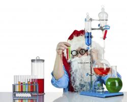Young person dressed as Santa plays with a chemistry set.