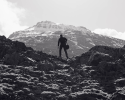 silhouette of a mountain climber standing in front of a mountain