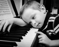 Young boy at the piano keyboard.