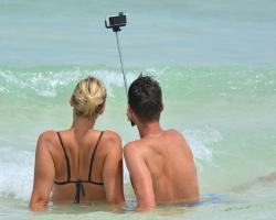 People taking a selfie at the beach.